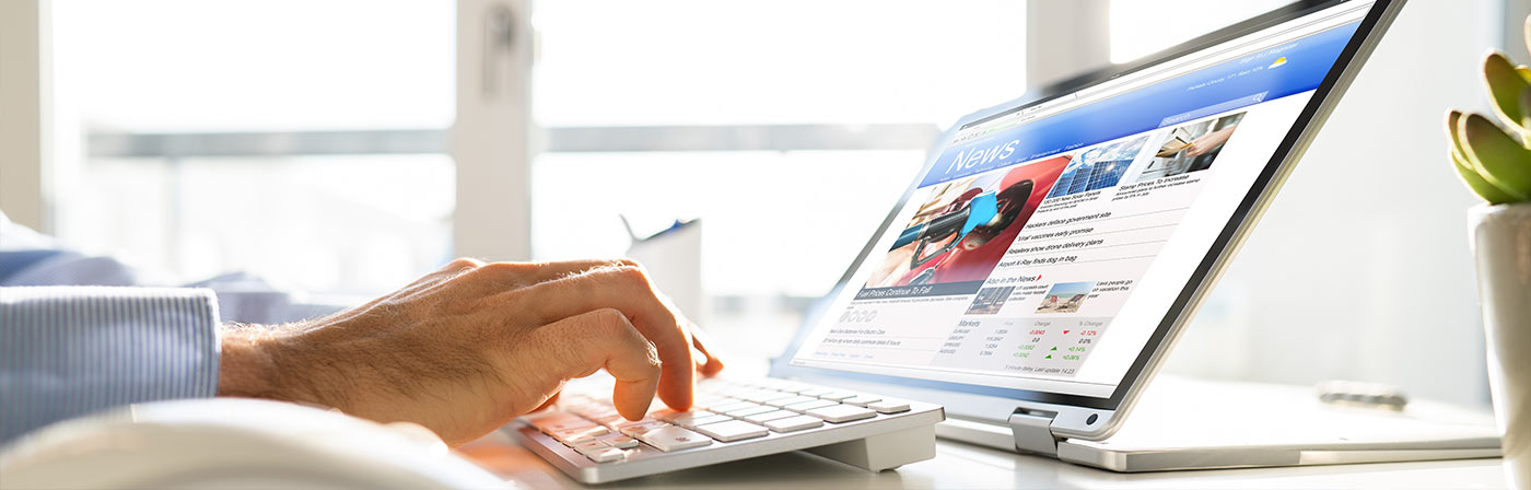 person reading the news on a laptop